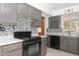 A kitchen showcasing a modern range, backsplash, ample cabinetry and granite countertops at 13012 N 26Th Dr, Phoenix, AZ 85029