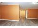 Bright living room with wood-look flooring, orange walls, and easy access to the entry and other rooms at 13012 N 26Th Dr, Phoenix, AZ 85029