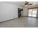 Open living room featuring tile flooring and sliding glass doors to the outdoor pool area at 13012 N 26Th Dr, Phoenix, AZ 85029