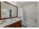 Bright bathroom with dark wood cabinets, large vanity mirror, and shower-tub combination at 1396 E Leslie Ave, San Tan Valley, AZ 85140