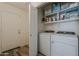 Laundry room with front load washer and dryer with shelving above and tile floors at 1396 E Leslie Ave, San Tan Valley, AZ 85140