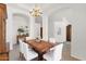 Stylish dining room with modern table, white chairs, classic chandelier, and minimalist decor, perfect for entertaining at 1420 W Raven Dr, Chandler, AZ 85286
