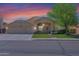 Charming home featuring a well-manicured lawn, mature tree, and a two-car garage, set against a beautiful sunset sky at 1420 W Raven Dr, Chandler, AZ 85286
