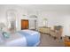 Bright main bedroom with white walls, carpet, and a chair plus connected bathroom and arched doorway at 1420 W Raven Dr, Chandler, AZ 85286