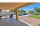 Cozy covered patio area with a view of the lush backyard and sparkling pool, perfect for entertaining at 1420 W Raven Dr, Chandler, AZ 85286