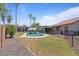 Spacious backyard featuring a refreshing pool, covered patio, and tall palm trees at 1670 E Whitten St, Chandler, AZ 85225