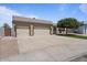 Beige home featuring a spacious driveway leading to a 2-car garage with a landscaped yard and lush tree at 1670 E Whitten St, Chandler, AZ 85225