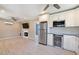 Open-concept living space with modern kitchen appliances, fireplace, wood-look tile flooring, and ceiling fan at 1670 E Whitten St, Chandler, AZ 85225