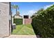 Side yard features artificial grass, tall shrubbery, and wood gate at 1670 E Whitten St, Chandler, AZ 85225