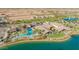 Aerial view of lakefront community amenities, including a pool, community center, and lush landscaping at 17219 W La Luz Rd, Surprise, AZ 85387