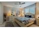 Comfortable bedroom with a ceiling fan, large window and neutral decor provides a peaceful retreat at 17219 W La Luz Rd, Surprise, AZ 85387