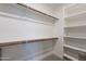 Walk-in closet featuring wooden rods, white shelves, and carpeted floor at 17219 W La Luz Rd, Surprise, AZ 85387