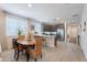 Inviting dining area with a wood table and woven chairs, situated near a kitchen and bathed in natural light at 17219 W La Luz Rd, Surprise, AZ 85387