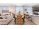 Open-concept dining area features a stylish table, counter seating, and a view into the adjacent living room with modern design at 17219 W La Luz Rd, Surprise, AZ 85387