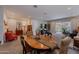 Open concept dining area features a wood table, tile floors and seamless flow to the living room at 17219 W La Luz Rd, Surprise, AZ 85387