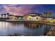 Stunning lakefront community with clubhouse, beautiful landscaping, and palm trees at sunset at 17219 W La Luz Rd, Surprise, AZ 85387