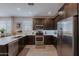 Modern kitchen boasts stainless steel appliances, dark wood cabinetry, and bright white countertops at 17219 W La Luz Rd, Surprise, AZ 85387