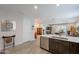 Open-concept kitchen with dark cabinetry, quartz countertops, and modern appliances, flowing into the living area at 17219 W La Luz Rd, Surprise, AZ 85387