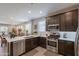 Modern kitchen featuring dark cabinets, stainless steel appliances, and an open layout to a breakfast nook at 17219 W La Luz Rd, Surprise, AZ 85387