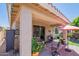 Covered patio with outdoor seating, garden, and sliding door entrance to the house at 17219 W La Luz Rd, Surprise, AZ 85387