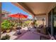 Covered patio space with potted plants, patio furniture and a red umbrella at 17219 W La Luz Rd, Surprise, AZ 85387