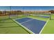 Outdoor pickleball courts fenced and ready for play, with landscaping and lighting at 17219 W La Luz Rd, Surprise, AZ 85387