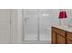 Walk-in shower with a glass door and a white tile surround at 1725 E Chanute Pass --, Phoenix, AZ 85040