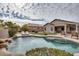 Aerial view of backyard with large swimming pool, waterfall, and seating areas on artificial turf at 17562 W Agave Ct, Goodyear, AZ 85338