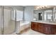 Bright bathroom featuring a glass shower, soaking tub, dual sink vanity and decorative window at 17562 W Agave Ct, Goodyear, AZ 85338