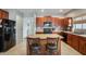 This kitchen features an island with barstool seating, dark cabinets, and tile flooring at 17562 W Agave Ct, Goodyear, AZ 85338