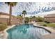 Beautiful backyard swimming pool with rock waterfall and lounge chairs, surrounded by desert landscaping at 17562 W Agave Ct, Goodyear, AZ 85338