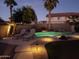 Backyard swimming pool featuring waterfall, rock features, desert landscaping and lounge seating at 17562 W Agave Ct, Goodyear, AZ 85338