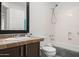 Bright bathroom with a black-framed mirror over a vanity and a shower-tub combination at 18031 N 12Th Pl, Phoenix, AZ 85022