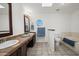 Bathroom featuring double sinks, a built-in tub, and a separate toilet for added convenience at 18031 N 12Th Pl, Phoenix, AZ 85022