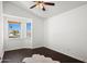 A bright bedroom featuring dark floors, a ceiling fan, and a bay window for plenty of natural light at 18031 N 12Th Pl, Phoenix, AZ 85022