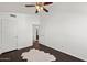A bedroom features a neutral color scheme, dark floors, a ceiling fan, and access to the ensuite bathroom at 18031 N 12Th Pl, Phoenix, AZ 85022