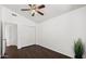 A bright bedroom featuring dark floors, a ceiling fan, and sliding door closet for efficient space utilization at 18031 N 12Th Pl, Phoenix, AZ 85022