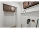 Bright laundry room with built-in cabinets, shelving and white walls at 18031 N 12Th Pl, Phoenix, AZ 85022