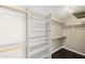 A fully organized walk-in closet with white shelves and wooden rods offering ample storage space at 18031 N 12Th Pl, Phoenix, AZ 85022