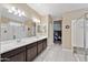 Bathroom with double sink vanity, walk-in closet, and glass-enclosed shower at 18309 N Crestview Ln, Maricopa, AZ 85138