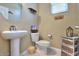 A half bathroom features a pedestal sink, toilet, and vanity with wicker drawers at 18309 N Crestview Ln, Maricopa, AZ 85138