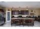 Modern kitchen features an island with granite countertop, pendant lights and three bar stools at 18309 N Crestview Ln, Maricopa, AZ 85138