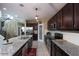 Modern kitchen features an island with granite countertop, stainless steel appliances and view to stairs at 18309 N Crestview Ln, Maricopa, AZ 85138
