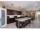 Modern kitchen features an island with granite countertop, pendant lights and seating at 18309 N Crestview Ln, Maricopa, AZ 85138