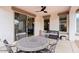 Cozy covered patio with a ceiling fan, dining table, and seating at 18309 N Crestview Ln, Maricopa, AZ 85138