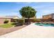 Backyard view features a pool with waterfall, lush trees, and pavers at 18649 W Williams St, Goodyear, AZ 85338