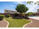 Landscaped backyard with artificial turf, mature trees, pavers and a waterfall pool at 18649 W Williams St, Goodyear, AZ 85338