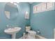 Powder room features a blue color scheme with a round mirror and white fixtures at 18649 W Williams St, Goodyear, AZ 85338