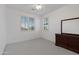 Well-lit bedroom featuring neutral carpet, a dark wood dresser, and bright windows at 18649 W Williams St, Goodyear, AZ 85338