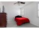 Cozy bedroom with red bedding, ceiling fan, and bright windows with shutters at 18649 W Williams St, Goodyear, AZ 85338